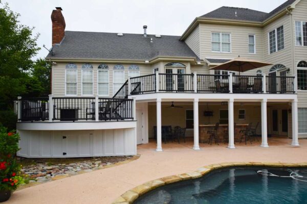 Two-tiered deck with storage and patio underneath overlooking pool in Ballwin, MO