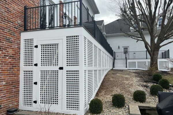 Custom Open Deck with white lattice storage door and black railing in Frontenac, MO