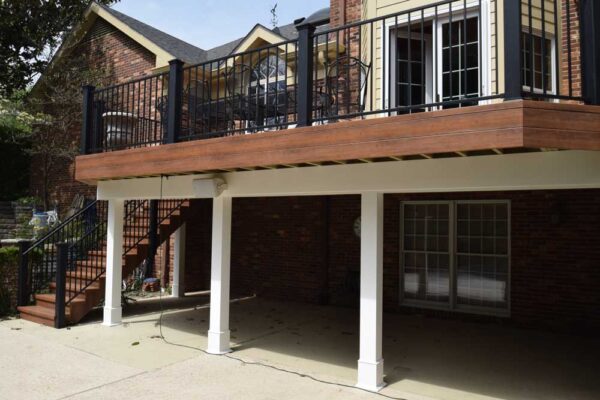 Open deck with black railings and patio underneath in Frontenac, MO