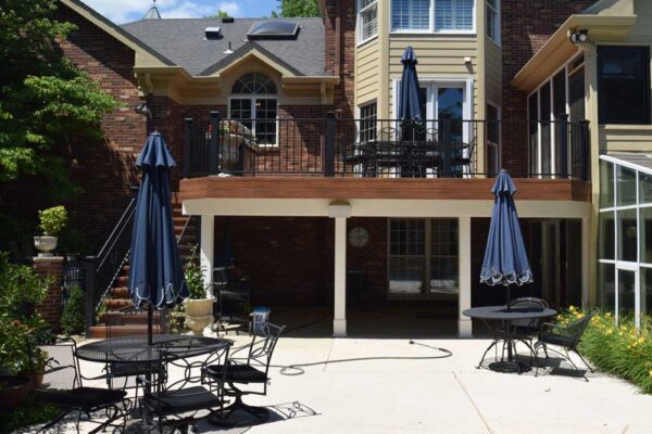 Open deck with black railings and patio underneath in Frontenac, MO