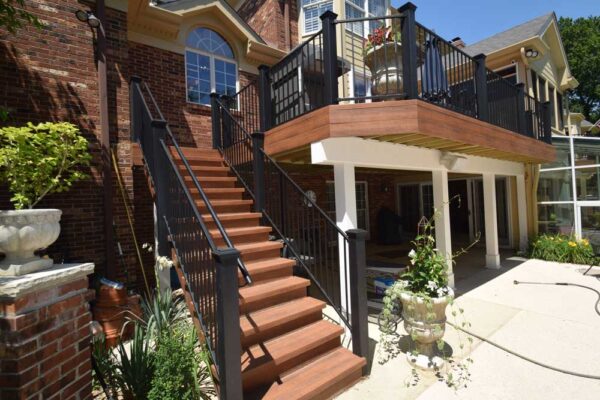Open deck with black railings and patio underneath in Frontenac, MO
